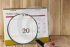 Magnifying glass in hand on calendar you can look Twentieth day