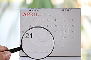 Magnifying glass in hand on calendar you can look Twentieth one