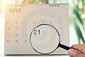 Magnifying glass in hand on calendar you can look Twentieth one