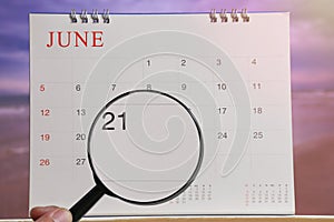 Magnifying glass in hand on calendar you can look Twentieth one