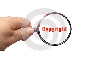 Magnifying glass in hand and a copyright word on the white background