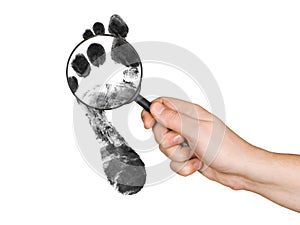 Magnifying glass in hand and foot printout