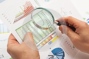 Magnifying glass in hand and paper