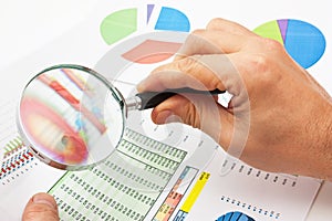 Magnifying glass in hand and paper