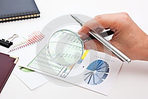 Magnifying glass in hand and paper