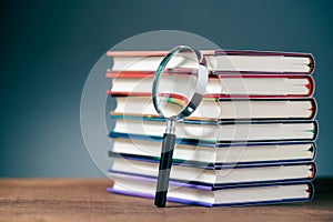 Magnifying glass and hardcover books