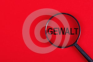 Magnifying glass with the inscription GEWALT on a red background photo