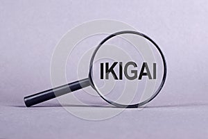 Magnifying glass with the inscription IKIGAI on a light gray background photo
