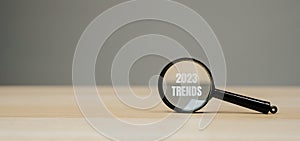 Magnifying glass with the inscription Trends 2023. The concept of searching for new ideological trends and tendencies. Exclusive