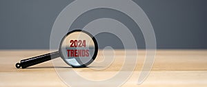 Magnifying glass with the inscription Trends 2024. The concept of searching for new ideological trends and tendencies. Exclusive