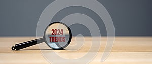Magnifying glass with the inscription Trends 2024. The concept of searching for new ideological trends and tendencies. Exclusive photo