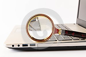 Magnifying glass and laptop on a light background. The concept of searching for information on the Internet. Selective focus