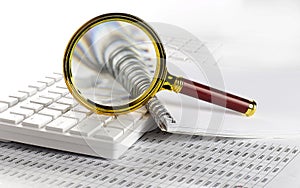 Magnifying glass lies on white laptop keyboard closeup background. Businees research concept