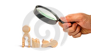 Magnifying glass is looking at a broken wooden human figure and a mother with a void in the body. Strife in the family. One parent