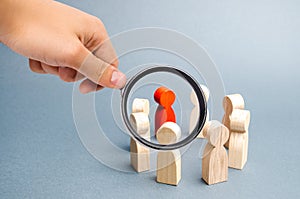 Magnifying glass is looking at the People stand in a circle on a gray background. Communication. Business team, teamwork, team