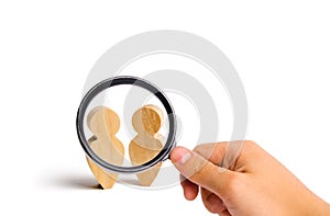 Magnifying glass is looking at the Two people stand together and talk. conduct a conversation on a white background. Place for tex