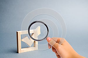 Magnifying glass is looking at the wooden checkmark for voting on elections on a gray background. Presidency or parliamentary photo