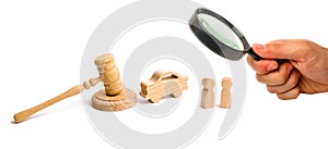 Magnifying glass is looking at the Wooden figurine of a car with people in a hammer of the judge on a white background. Minimalism