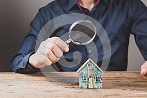 Magnifying glass looks at the house. home search concept