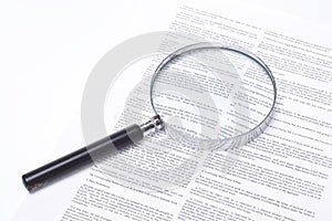 Magnifying glass lying on a legal contract photo