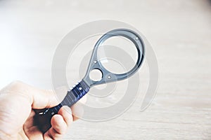 Magnifying glass in a man hand. Man holds a magnifier