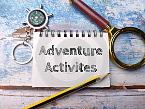 Magnifying glass and notebook with the word Adventure Activites