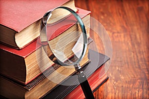 Magnifying glass with old books