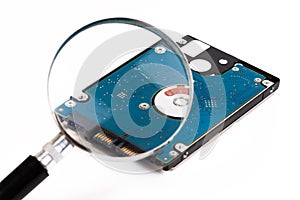 Magnifying glass over a computer hard drive. Hard disk of a laptop.