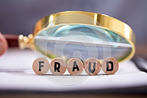 Magnifying Glass Over The Fraud Word