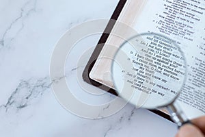 Magnifying glass over open holy buble book of psalms 139 verses, top view, searcing Scriptures concept