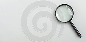 Magnifying glass over pale blue background with copy space. Horizontal banner with magnifier