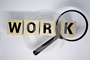 Magnifying glass over the word job wooden letters on yellow background. Top view, flat lay