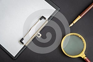 Magnifying glass and paper sheet with empty to do list and pen on black background