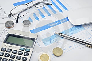 Magnifying glass, pen, glasses and calculator on financial chart