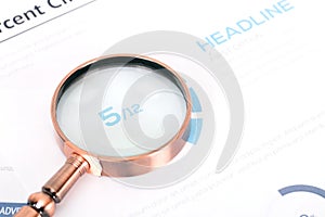 A magnifying glass is placed on a financial document