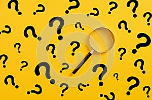 Magnifying glass and question mark signs on yellow background. Searching for information, data, solution or answer