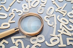 A magnifying glass and random wooden numbers photo