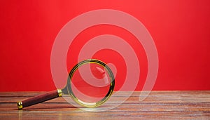 Magnifying glass on a red background. Search and analysis, analytics and study. Pay attention to details and problems. Find