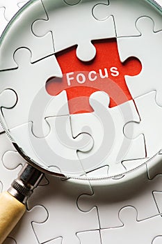 Magnifying glass searching missing puzzle peace FOCUS