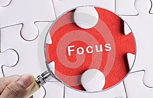 Magnifying glass searching missing puzzle peace FOCUS