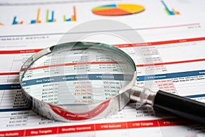 Magnifying glass on spreadsheet and graph paper. Financial, Banking Account, data economy, Business concept