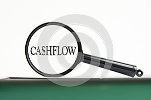 magnifying glass with text Cashflow on notebook
