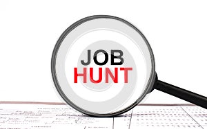 Magnifying glass with text Job Hunt on financial tables