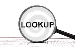 Magnifying glass with text Lookup on financial tables photo