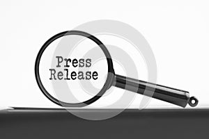 magnifying glass with text press release on notebook