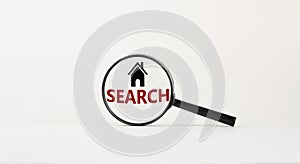 Magnifying glass with text `search` and house icon on beautiful white background. Business concept, copy space