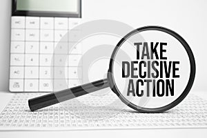 Magnifying glass with text TAKE DECISIVE ACTION on white table with calculator