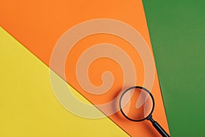 Magnifying glass on three color background