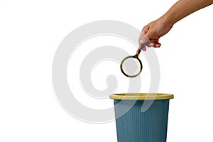 Magnifying glass is thrown into trash.Concept of meaningless search photo