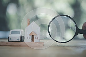 Magnifying glass with a toy house and a car